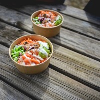 two poke bowls with raw organic ingredients on a wooden table outdoors. - junk food stock pictures, royalty-free photos & images