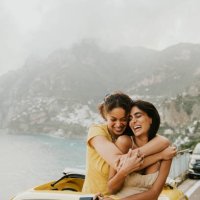 two woman enjoy experiential travel in a rented vintage car in italy. they hug. - travel stock pictures, royalty-free photos & images