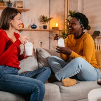 two women eating ordered food together at home - junk food stock pictures, royalty-free photos & images