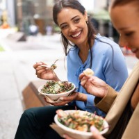 two women enjoying healthy salads outdoors in downtown sydney - junk food stock pictures, royalty-free photos & images