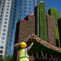 Two workers set up parterre decorations by a corner of a street in Beijing on June 17, 2021.
