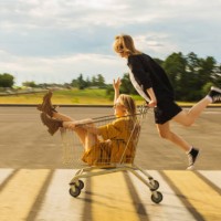 two young blonde girls have fun with shopping cart. fashion woman - fashion stock pictures, royalty-free photos & images