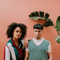 two young, fashionable models look confident as they stand beside each other and look at the camera - fashion stock pictures, royalty-free photos & images