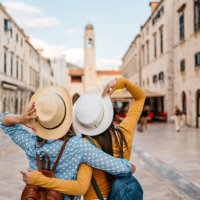 two young female friends embracing on the street in dubrovnik - travel stock pictures, royalty-free photos & images