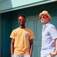 two young men posing outside in the sunshine wearing sunglasses and a hat - fashion stock pictures, royalty-free photos & images