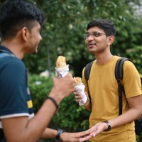 two young men standing on a city street and eating taco - junk food stock pictures, royalty-free photos & images