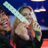 two young women holding tickets and smiling at an event - concert stock pictures, royalty-free photos & images