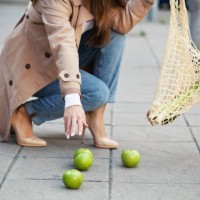 une jeune femme dépose des courses sur le trottoir - food photos et images de collection