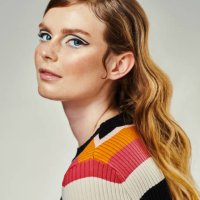 une jolie jeune femme habillée en tenue des années 60 sur un fond de studio gris. portrait d’un beau mannequin regardant l’appareil photo habillé dans un style rétro - hairstyle photos et images de collection
