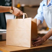 unrecognizable female employee giving packed order to a customer - junk food stock pictures, royalty-free photos & images
