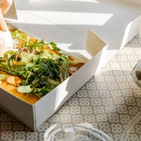 unrecognizable person cutting vegan dish in paper container - junk food stock pictures, royalty-free photos & images