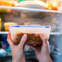 unrecognizable woman putting a tupper with food in the refrigerator - food stock-fotos und bilder