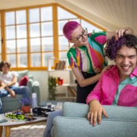 urban young woman with pink hair curling her male friend hair - fashion stock pictures, royalty-free photos & images