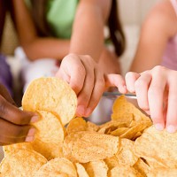 usa, california, los angeles, three girls (10-11) reaching for crisps - junk food stock pictures, royalty-free photos & images