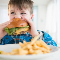 usa, new jersey, jersey city, portrait of boy (4-5) eating hamburger - junk food stock pictures, royalty-free photos & images