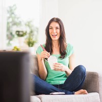 usa, new jersey, jersey city, portrait of woman watching tv and eating take out food - junk food stock pictures, royalty-free photos & images