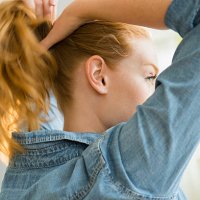 usa, new jersey, young woman tying hair - hairstyle stock pictures, royalty-free photos & images