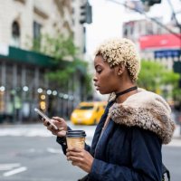 usa, new york city, fashionable young woman with coffee to go looking at cell phone on the street - hairstyle stock pictures, royalty-free photos & images