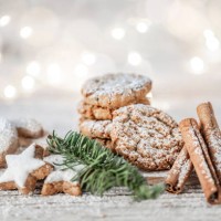 vegan oatmeal cookies with powdered sugar, cinnamon sticks and cinnamon stars on a wooden table at christmas. - food stock pictures, royalty-free photos & images
