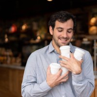 very happy man juggling with cups of coffees and leaving a cafe - junk food stock pictures, royalty-free photos & images
