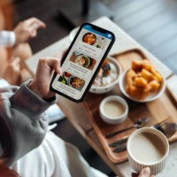 viajero de la generación z usando una aplicación de entrega de comida en un teléfono inteligente - food fotografías e imágenes de stock