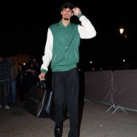 Victor Wembanyama wears sunglasses, a green and white teddy jacket with monogram logo print from Louis Vuitton, black flared pants, black leather...