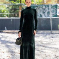 Victoria Magrath wears green velvet dress, bag, black boots outside Akris during the Womenswear Spring/Summer 2024 as part of Paris Fashion Week on...