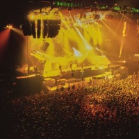 View of the audience as British band Oasis performs on stage, circa 1980.