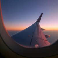 view through airplane window during flight at sunset - travel stock pictures, royalty-free photos & images