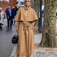 Viktoria Rader wears brown cape, trench coat, black bag, heeled shoes outside Chloe during Womenswear Spring/Summer 2025 as part of Paris Fashion...