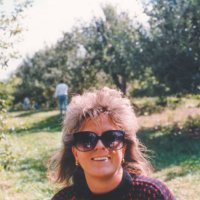 vintage 1980s hairstyle, stylish 1990s hair, happy woman wearing sunglasses outdoors apple picking - hairstyle stock-fotos und bilder
