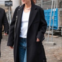 Vittoria Ceretti wears white tank top, blue jeans, black long coat, black loafers, black Balenciaga sunglasses, outside Miu Miu, during the...
