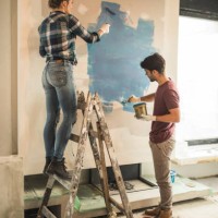 volledige lengte van jong koppel hun muren schilderen tijdens huisvernieuwing. - home decoration stockfoto's en -beelden