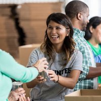 volunteer accepts canned food donation at food drive - food stock pictures, royalty-free photos & images