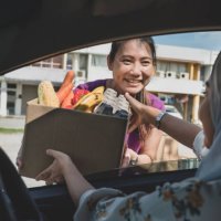 volunteers hands out food at drive through food bank - food stock pictures, royalty-free photos & images