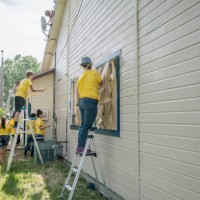 volunteers on ladders painting house - home decoration stock pictures, royalty-free photos & images