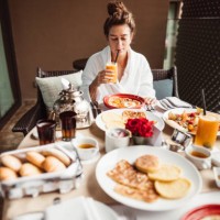 vrouw aan de tafel voor het ontbijtbuffet met fruit - food stockfoto's en -beelden