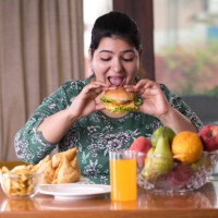 vrouw eten een fast food hamburger - food stockfoto's en -beelden