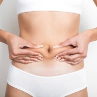 vrouw knijpen van haar buik op witte achtergrond - junk food stockfoto's en -beelden