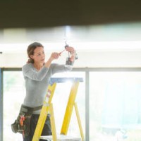 vrouwelijke elektricien installeren downlighters - home decoration stockfoto's en -beelden