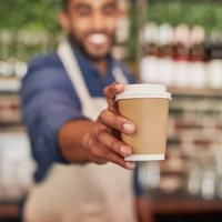 waiter, coffee cup and man giving drinks in cafe, shop or restaurant. closeup barista, takeaway beverage and tea latte for hospitality service, fast food worker or catering startup in cafeteria lunch - coffee stockfoto's en -