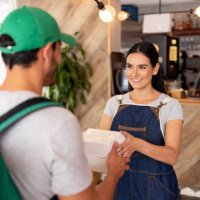 waitress handling a food order to a delivery person at a dark kitchen - junk food stock pictures, royalty-free photos & images