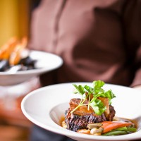 waitress holding plate of beef tenderloin - food stock pictures, royalty-free photos & images