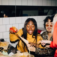 waitress pointing while woman with burger ordering food by friend in cafe - junk food stock pictures, royalty-free photos & images