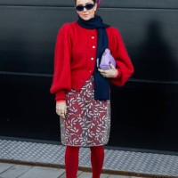 Wears navy scarf, red cardigan, transparent skirt with floral, red tights, purple bag outside Munthe during the Copenhagen Fashion Week AW24 on...
