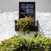 white facade with a wooden balcony adorned with flower pots. - garden decoration stock pictures, royalty-free photos & images