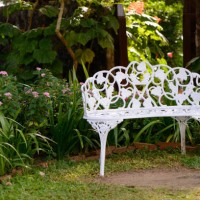 white metal bench in tropical garden - garden decoration stock pictures, royalty-free photos & images