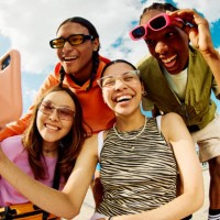wide angle shot of gen z group of friends using a smartphone together. - fashion stock pictures, royalty-free photos & images