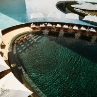 wide shot aerial view of family relaxing in pool at tropical resort - travel stock pictures, royalty-free photos & images