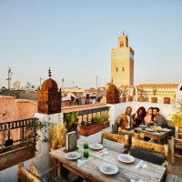 wide shot of couple taking selfie at rooftop restaurant in marrakech - travel stock-fotos und bilder
